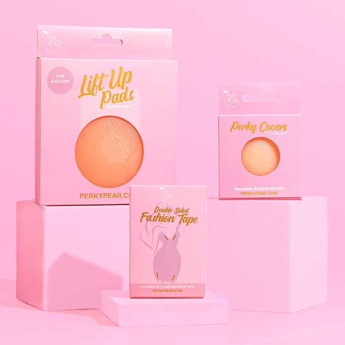 3 pink boxes containing boob tape, lift up pads and nipple covers - all pink boxes with pink background